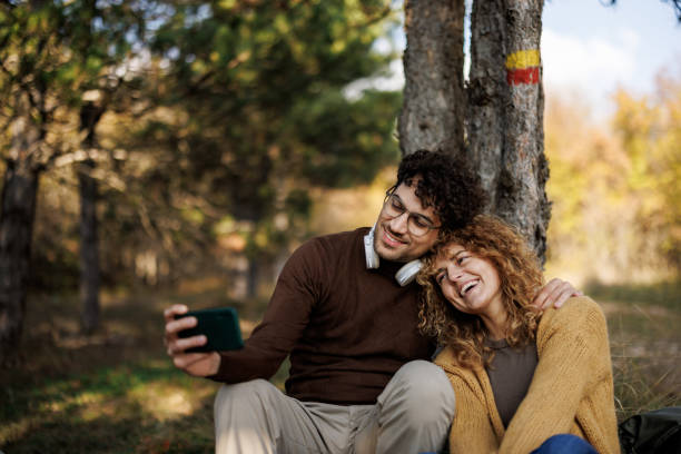 istock Happy couple taking selfie in sunny woods 2185703689