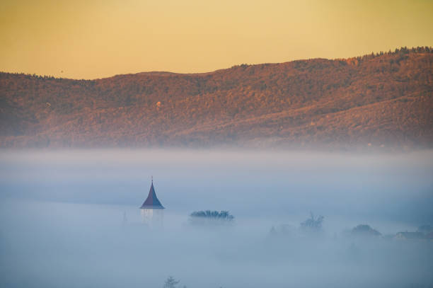 Church hidden in white autumn fog