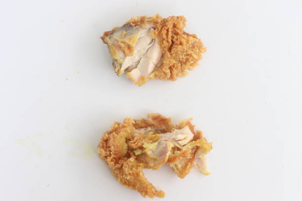 istock A piece of fried chicken is cut in half, revealing the meat inside. 2185705434