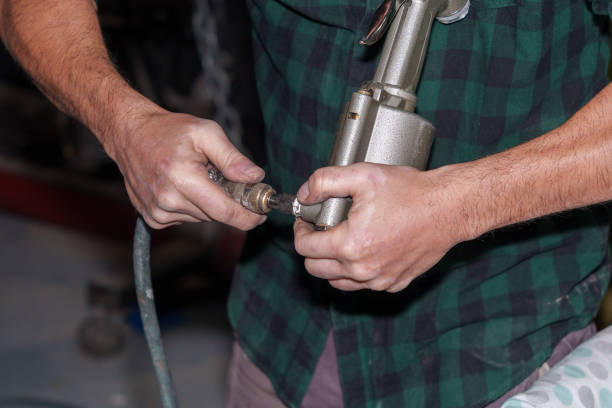 istock Mechanic connecting air hose to a pneumatic tool 2185710454