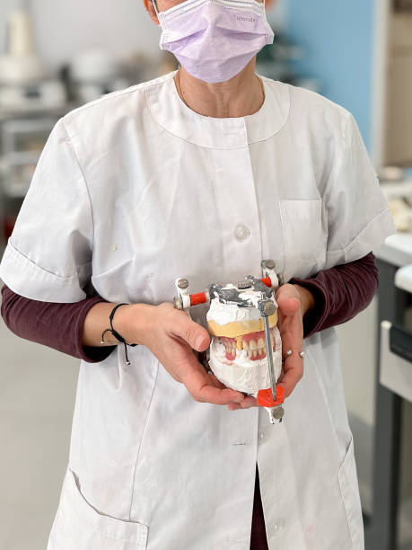 istock Woman dental technician holding a denture 2185710526