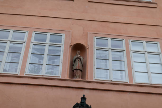 A beautifully crafted statue placed within a high wall niche serves as an intricate architectural feature, significantly enhancing the overall beauty of the city within an urban environment