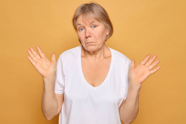 istock A woman with a puzzled expression raises her hands in a questioning gesture against a solid yellow background, reflecting confusion or uncertainty in a lighthearted manner 2185711226