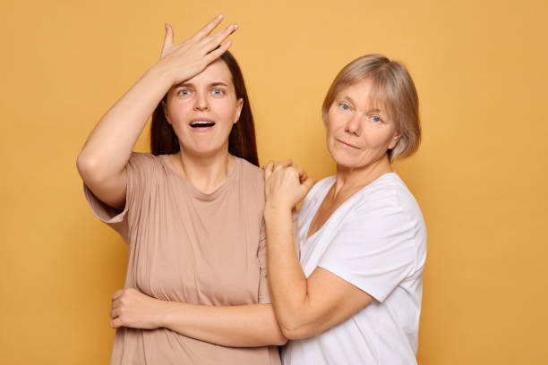 istock Two women express surprise and joy while posing together against a bright yellow background in a warm, friendly atmosphere 2185711266