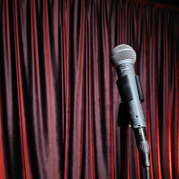 istock Microphone on Stage with Red Velvet Curtain Backdrop 2185715037