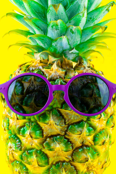 istock Pineapple with sunglasses isolated on yellow background 2185716353