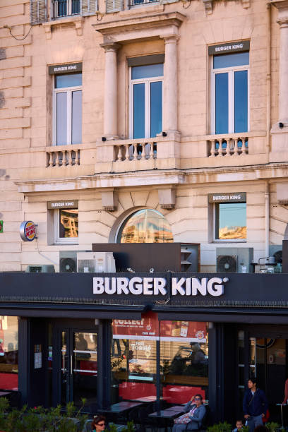 Marseille. France  - November 20,2024: Burger King restaurant located at the Old Port of Marseille, blending modern fast food branding with the historic harbor setting. Visible logos and signage amidst the maritime backdrop.