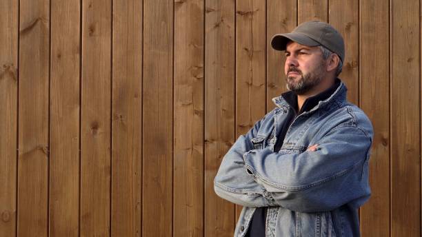 istock Man standing against wooden wall. Bearded 2185717565