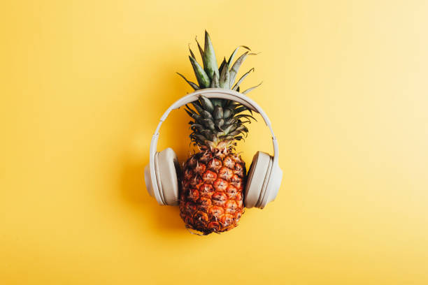 istock Pineapple in headphones on yellow background. Top view, flat lay 2185717910