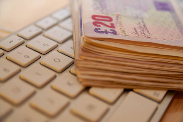 istock A stack of GBP British sterling pound bills on a computer keyboard 2185719454