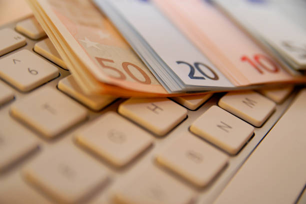 A stack of EUR european bills on a computer keyboard