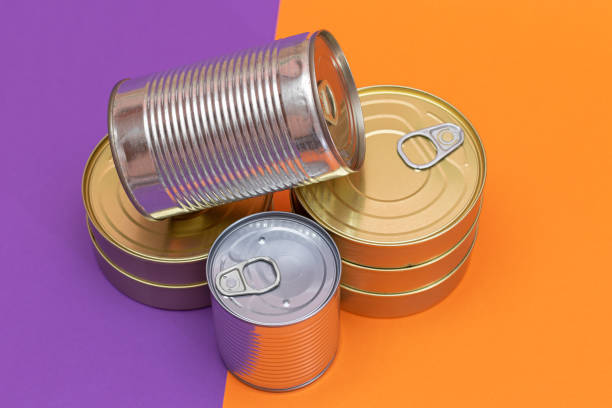 istock A Group of Stacked Tin Cans with Blank Edges on Split Orange and Violet Background 2185722258