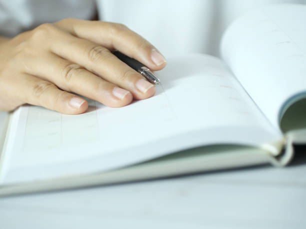 istock Hand holding pen writing on note paper. Finance business concept. Copy space. 2185722464