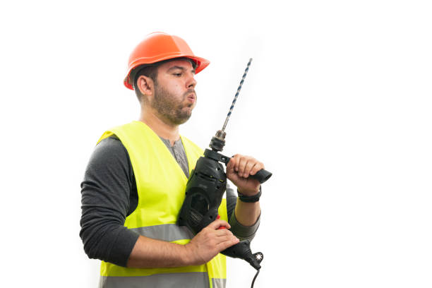 Construction worker using a cordless drill to work on a construction site