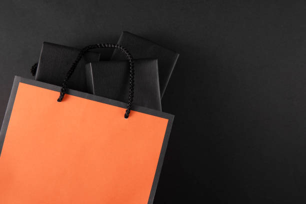 Shopping bag with black friday message on black colored background with copy space
