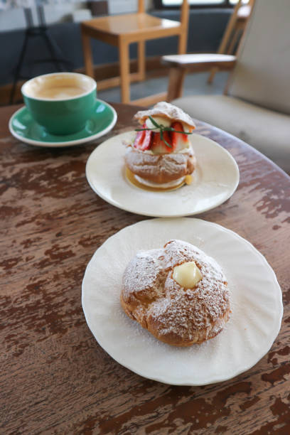 choux cream or cream puff, eclair or strawberry choux cream  and coffee  on the table