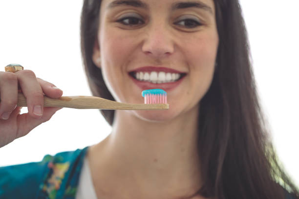 istock At home - young woman brushing her teeth 2185727045