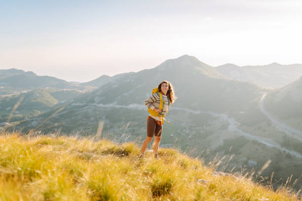 Woman on a hiking trip in the mountains having a break. Beautiful mountains landscape. Adventure active.