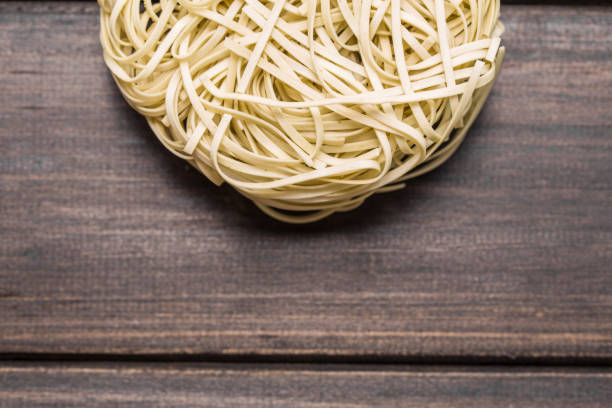 Heart made with spaghetti on white table, top view. Space for text