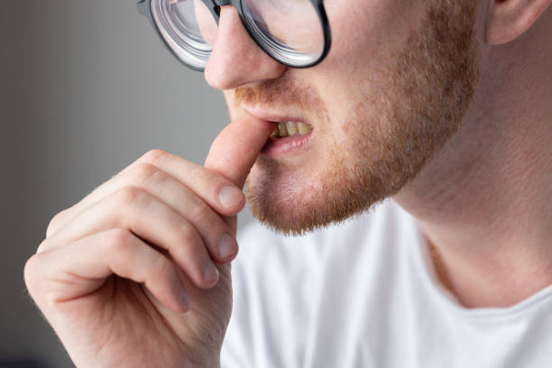 istock A man in glasses biting his fingernails. Unhygienic habits. 2185732267