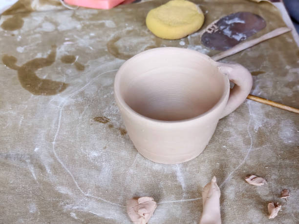istock Workshop for kids. Children learning how to use clay for making dishes. 2185745548