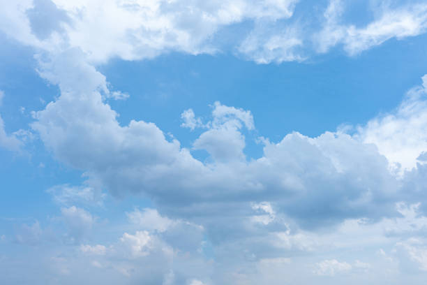 istock Fluffy white clouds drift across a bright blue summer sky 2185746056