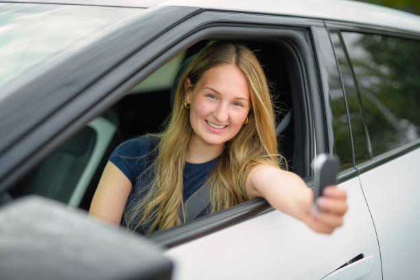 istock A beautiful woman with her new car 2185750667