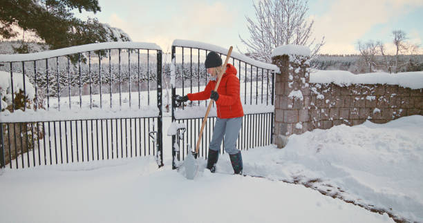 istock Senior woman clearing snow 2185753182