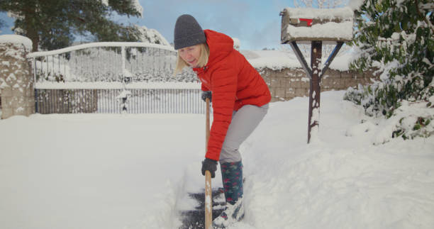 istock Senior woman clearing snow 2185753703