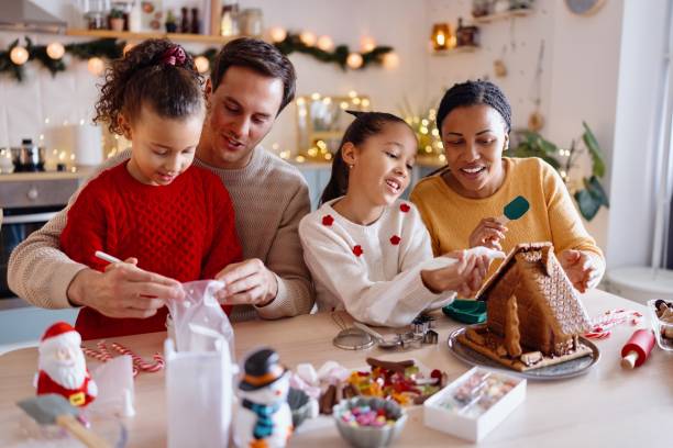 istock Family having fun making Gingerbread house at home 2185754443