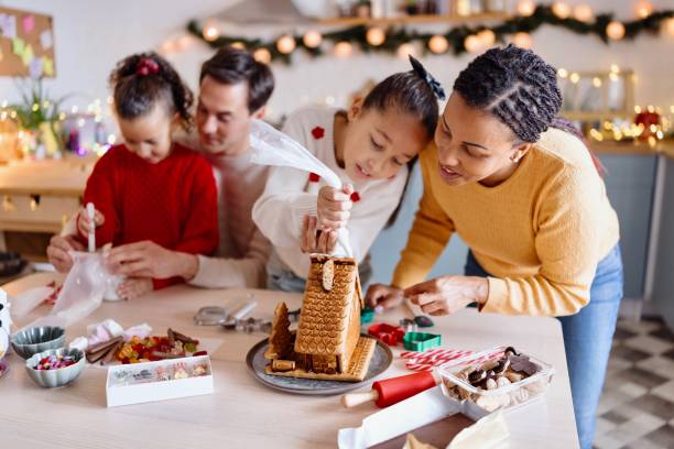 istock Family having fun decorating Gingerbread house 2185754449