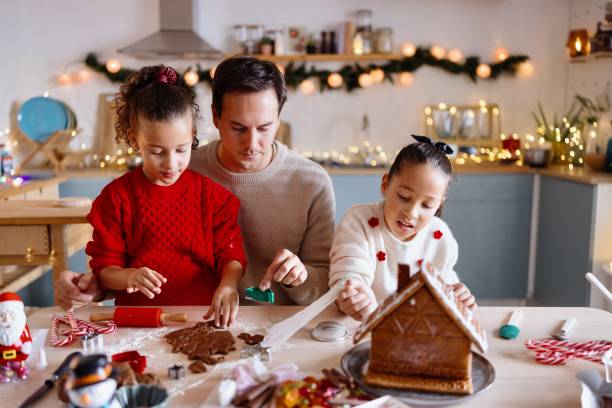 istock Father decorating a Gingerbread house with his daughters 2185754469