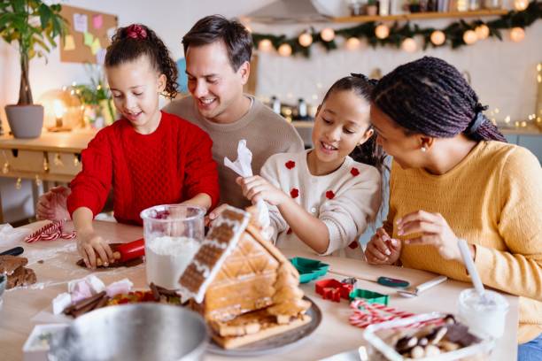 istock Creative family decorating Gingerbread house 2185754499