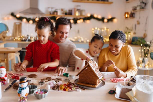 istock Family decorating a gingerbread house 2185754549