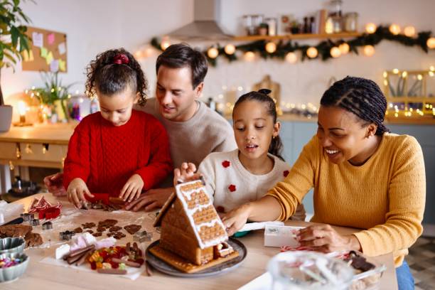 istock Lovely family decorating a Gingerbread house 2185754551