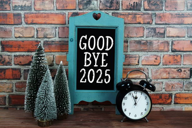 istock Goodbye 2025 text on blackboard easel stand with alarm clock on wooden and old brick wall background 2185755824