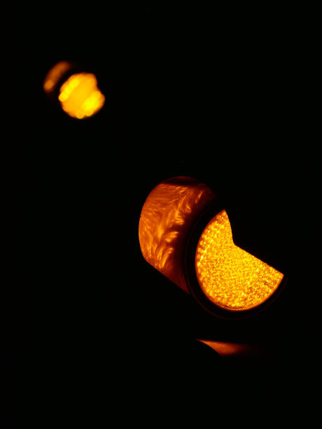 istock Yellow traffic light close up in the dark on a black background 2185764599