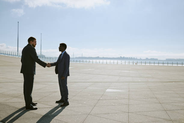 istock Business Professionals Shaking Hands Outdoors 2185765446