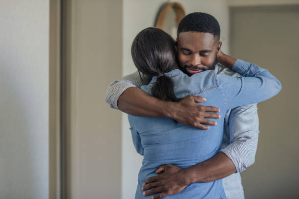 istock Affectionate young African American man hugging his wife at home 2185768029