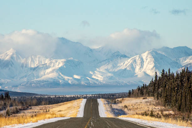 istock Highway in mountains and forest in fresh snow 2185769699