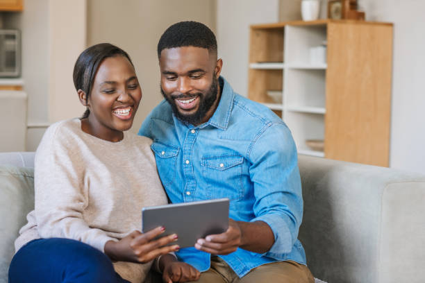 istock African American couple laughing while using a tablet at home 2185769767