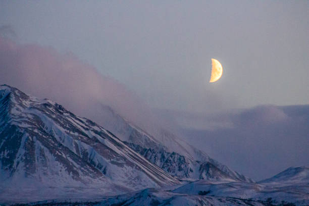 Moon rise over mountain peak in fresh snow, Kluane National Park and Reserve