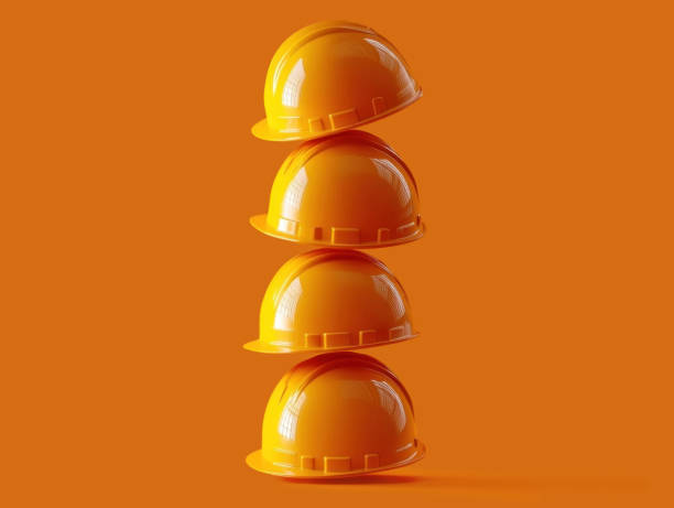 Minimalist composition featuring colorful hard hats stacked against a striking orange backdrop, ideal for construction, safety, and industrial themes.