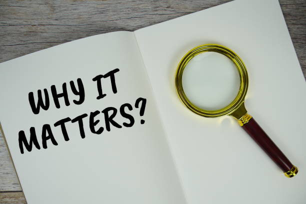 istock Why it matters? text on notebook page with magnifying glass top view on wooden background 2185773346