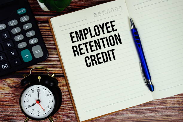 istock Employee retention text written on paper torn with calculaton and alarm clock top view on wooden background 2185773539