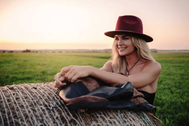 Cheerful Woman in Maroon Hat osing in a Field.