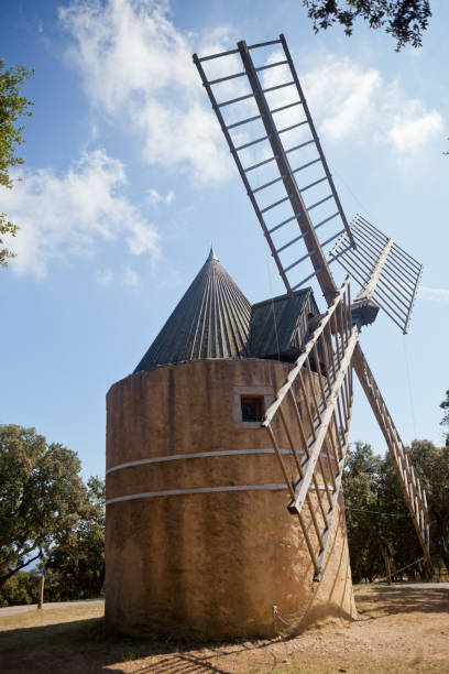 Traditional Windmill near Ramatuelle and St Tropez, on the Cote d'Azur, South of France The 19th century windmill, Moulin Paillas, on the hilltop above the Var village of Ramatuelle, near St Tropez. It is named after the last miller to use the windmill, Jean Baptiste Paillas. The mill used to supply the flour for the village bakery until the end of the 19th century old flour mill stock pictures, royalty-free photos & images