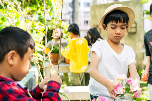 Childhood student and friends learning how to decorating flower vases in the garden at elementary School