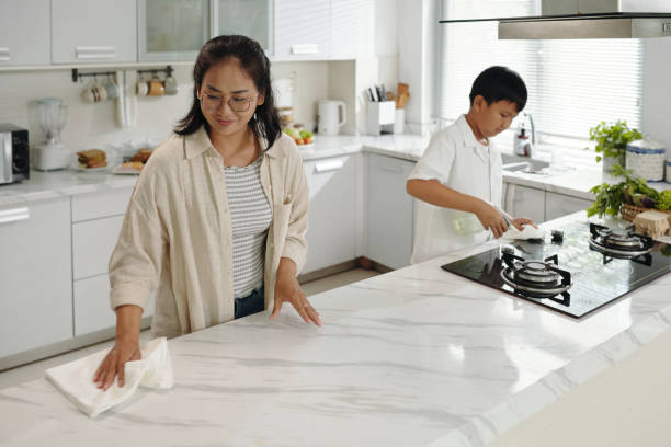 Cleaning Countertop and Cooking in Modern Kitchen