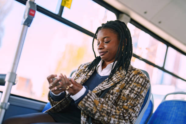 istock Young African woman using mobile phone on bus. 2185777750